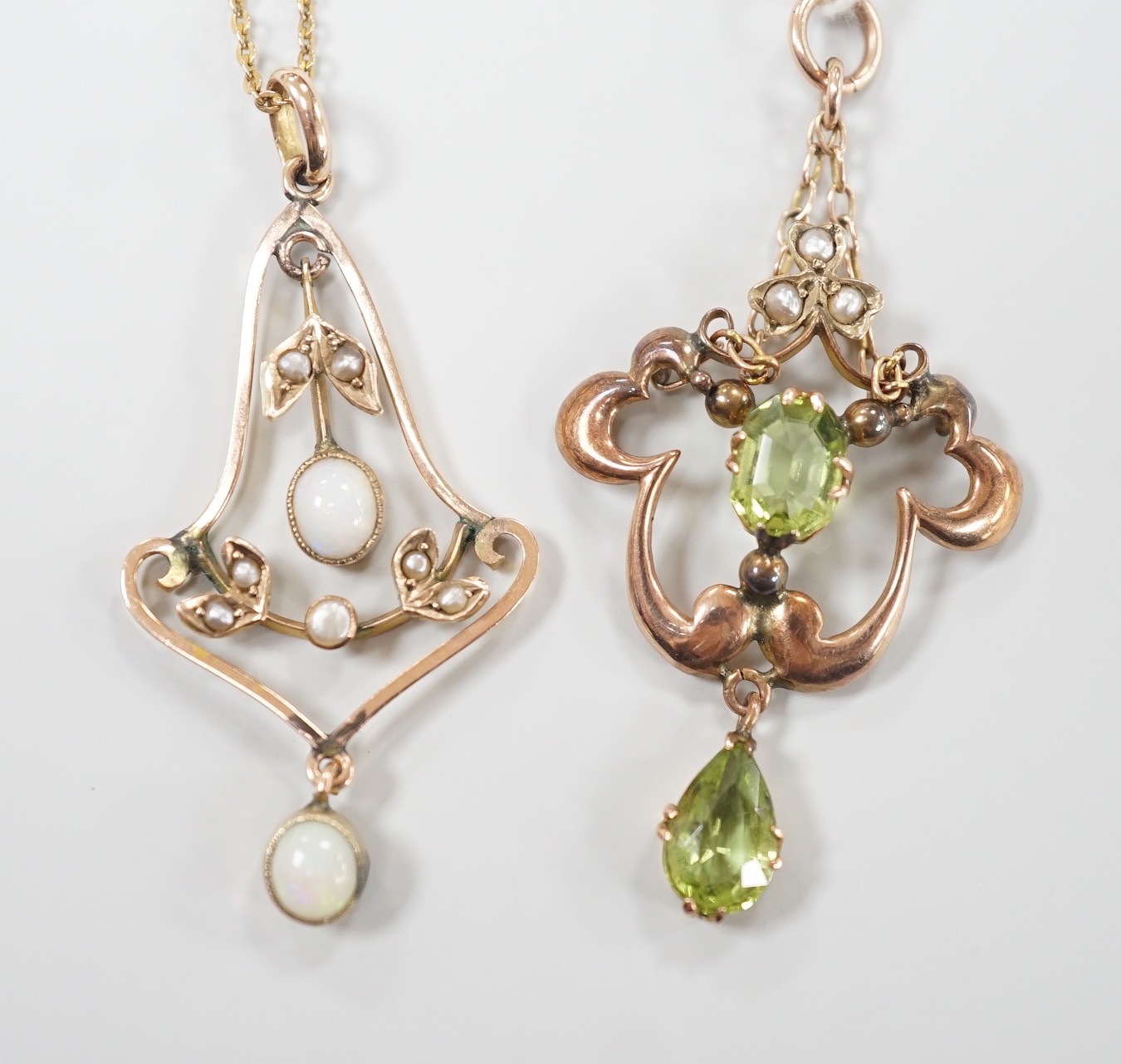 An early 290th century 9ct, peridot and seed pearl set drop pendant, overall 44mm and a similar yellow metal, white opal and seed pearl pendant on a 9ct chain, gross weight 6.4 grams.